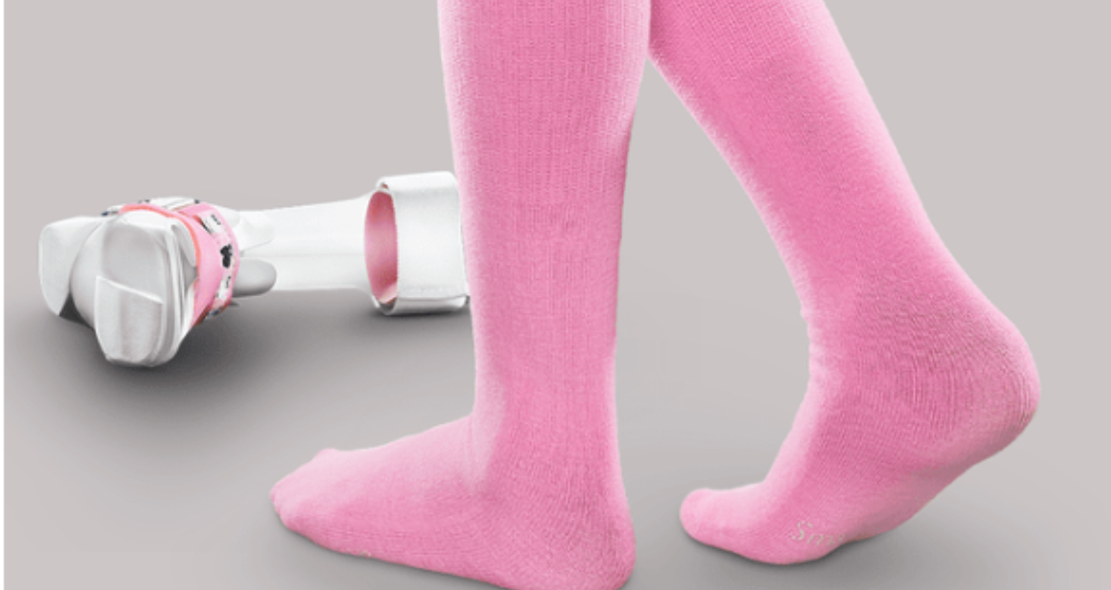 Legs wearing pink speciality socks and an AFO in the background