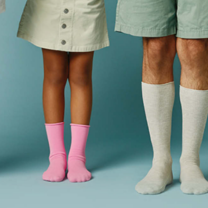 four people standing with just legs showing, wearing socks.