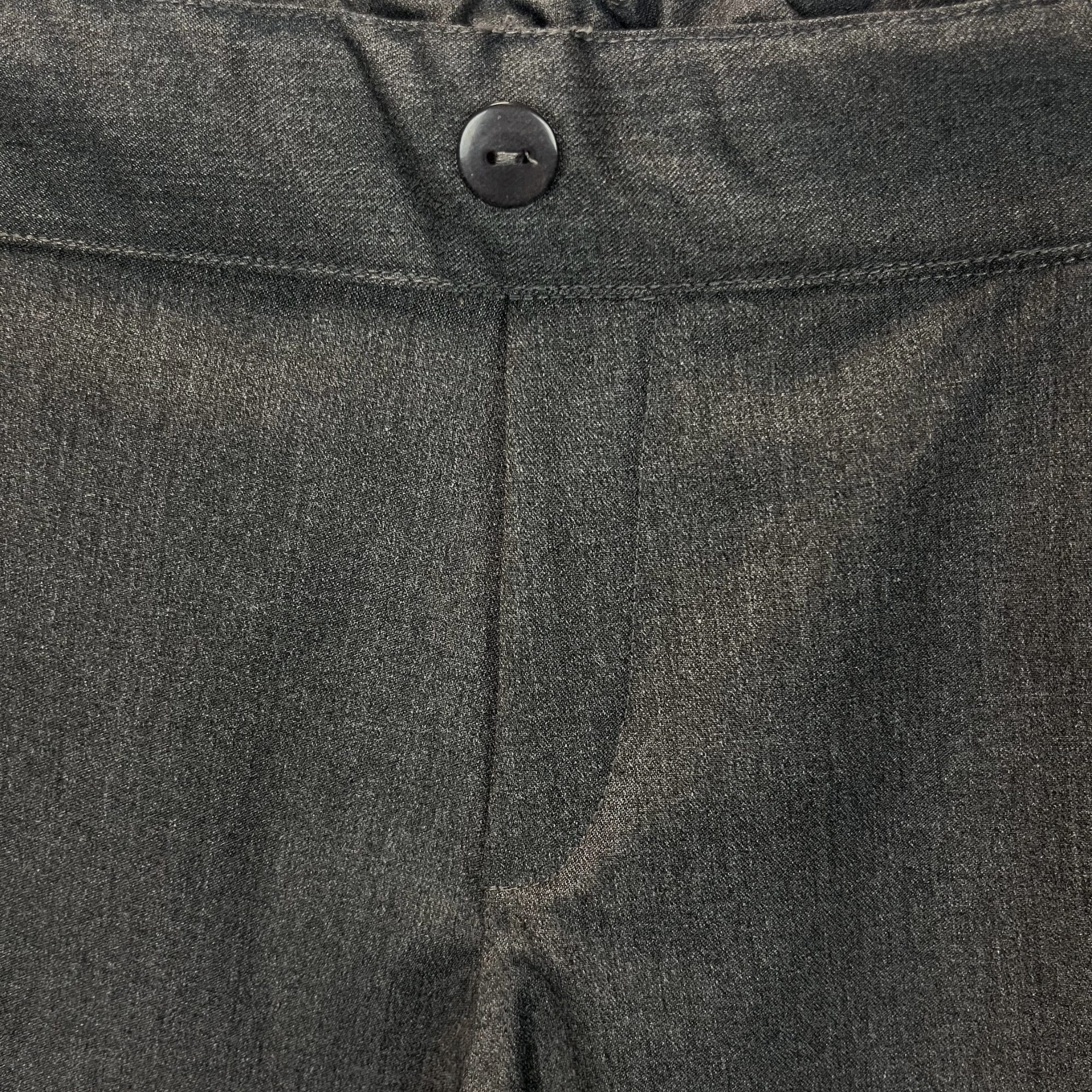 Close-up of charcoal school trouser waistband with non-functional button detail
